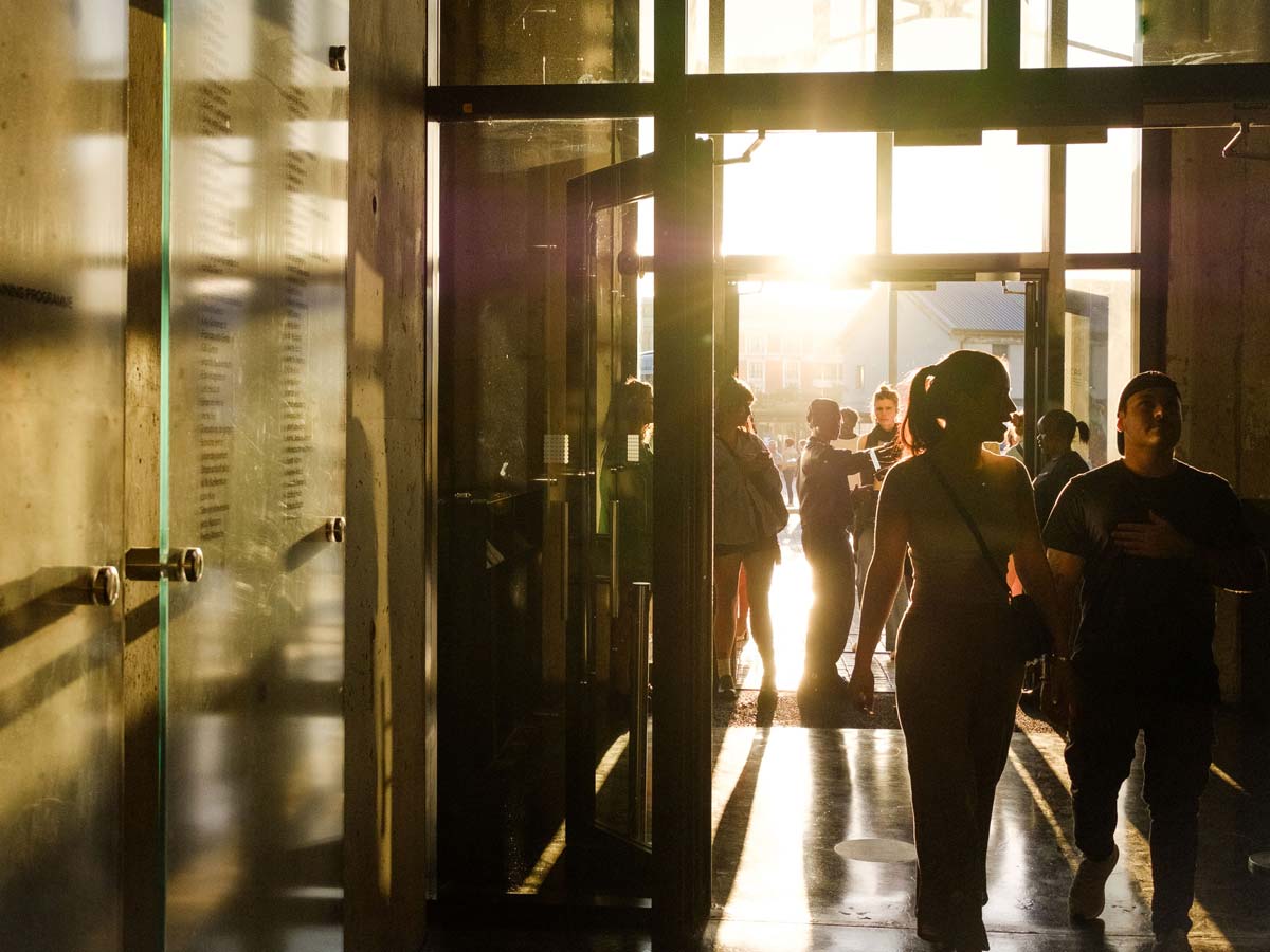 People silhouetted walking through glass doors at the Zeitz Museum of Contemporary African Art