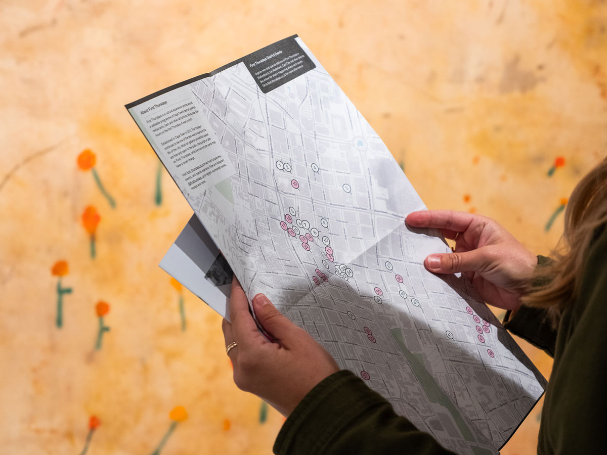 Person holding a First Thursdays Cape Town map with event locations