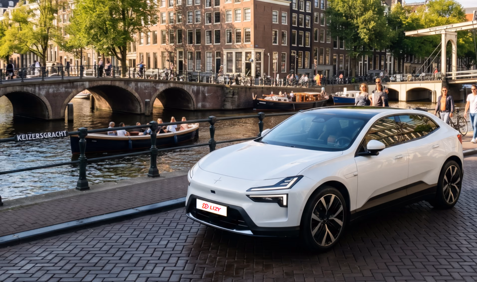 Een jong gebruikte witte Polestar 4 van LIZY geparkeerd langs een kanaal met een boot en brug in Amsterdam.