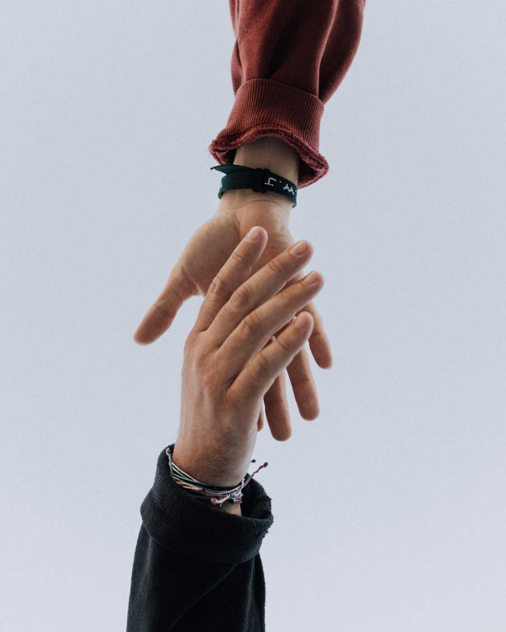 Two people reaching for each others hands.