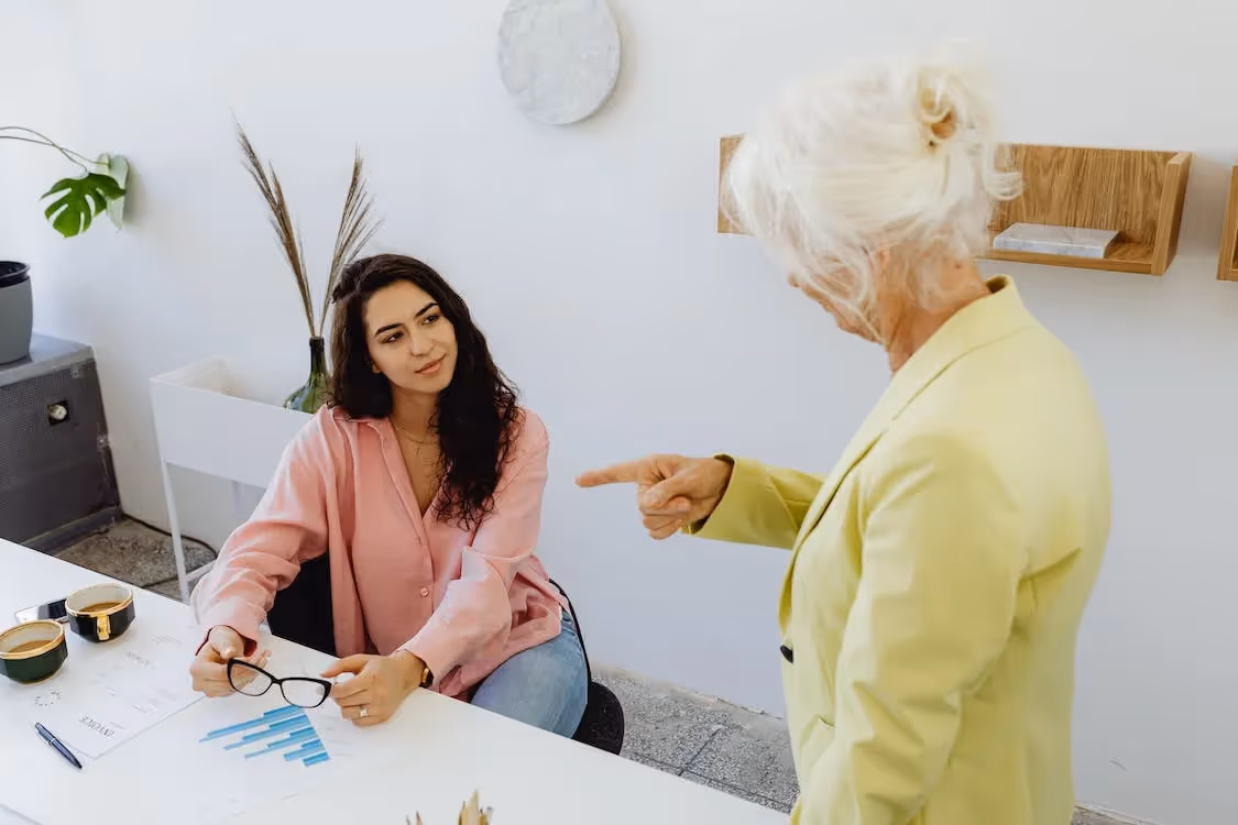 Curly Haired Woman Looking at Gray Haired Woman