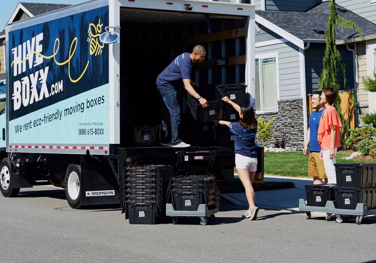 a moving truck with people moving plastic tubs