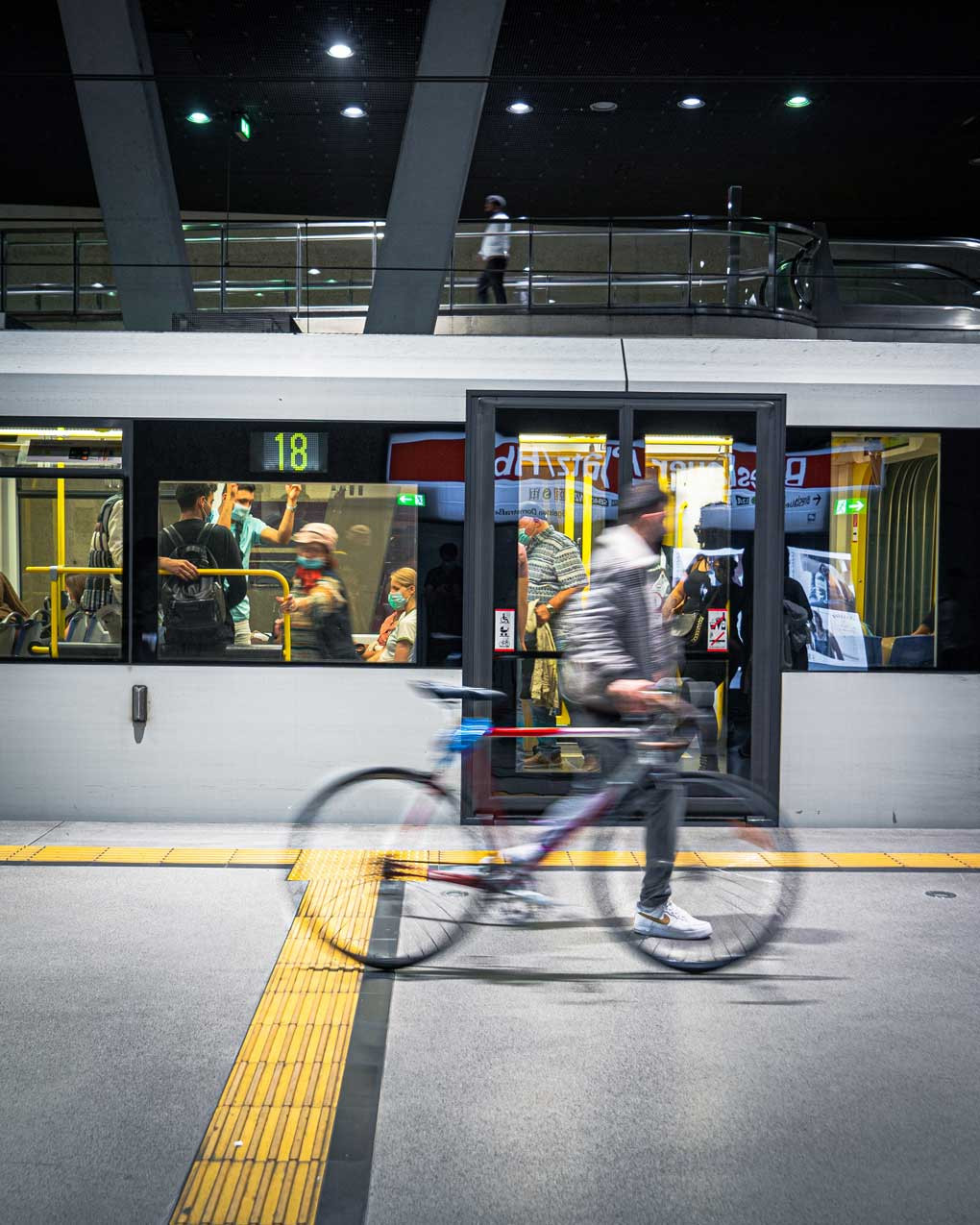 a person walking a bike by a public transit train