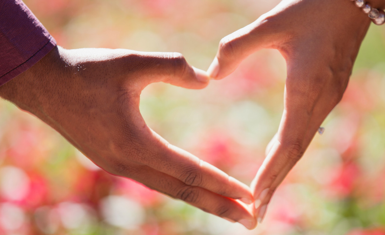 Two people making a heart with their hands
