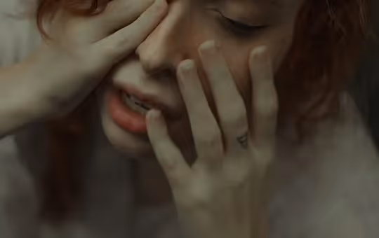 Woman holding her hands to her face