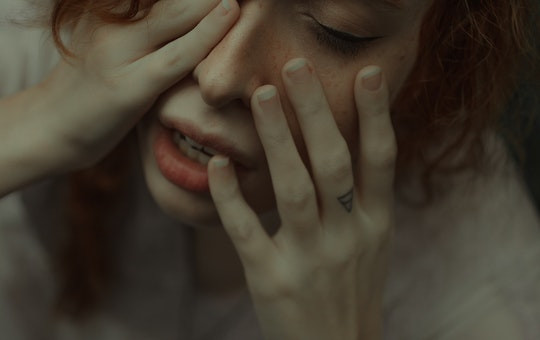 Woman holding her hands to her face