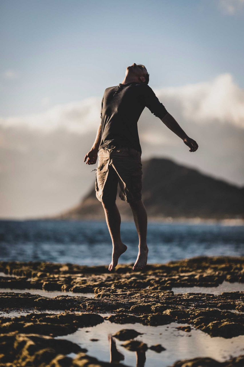 a man looking up to the sky while jumping