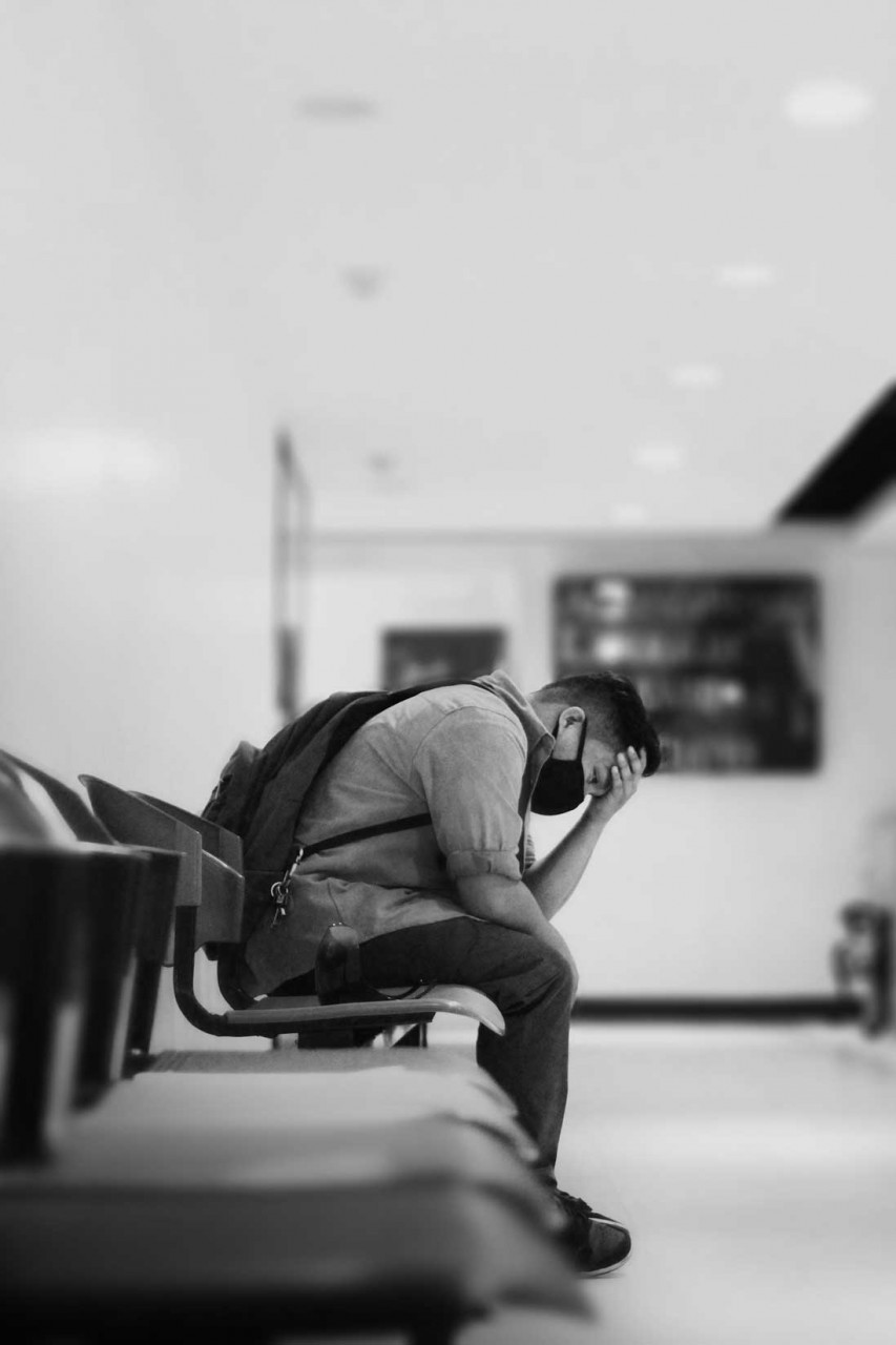 a person sitting with their head in their hand