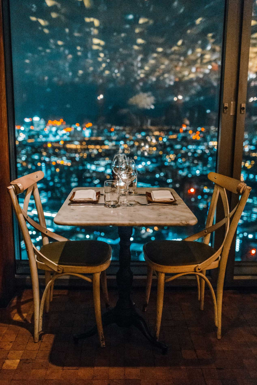 a table with two chairs overlooking a city