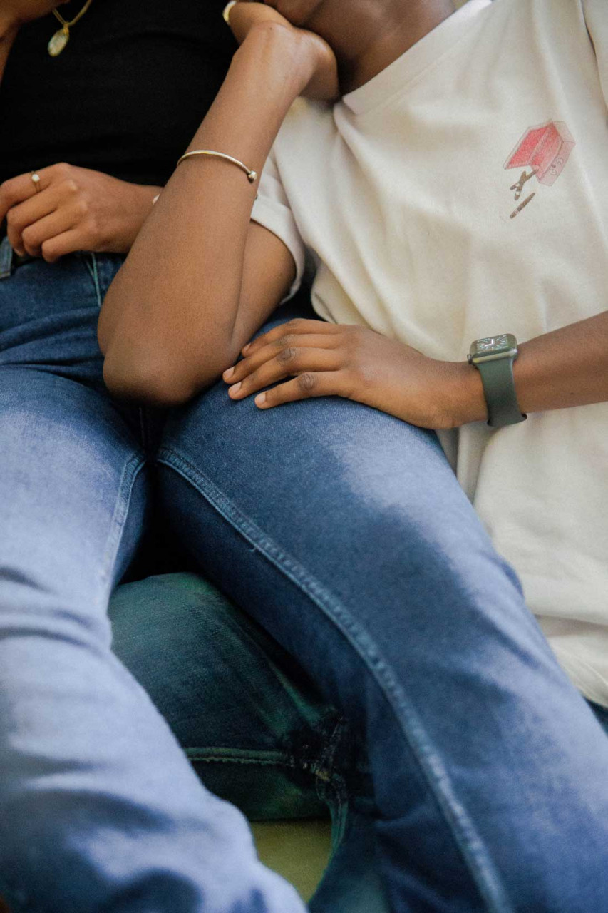 two people sitting together one person has their hand on the others leg