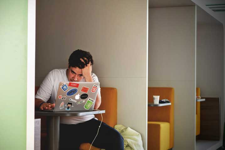 a frustrated person looking at their computer screen