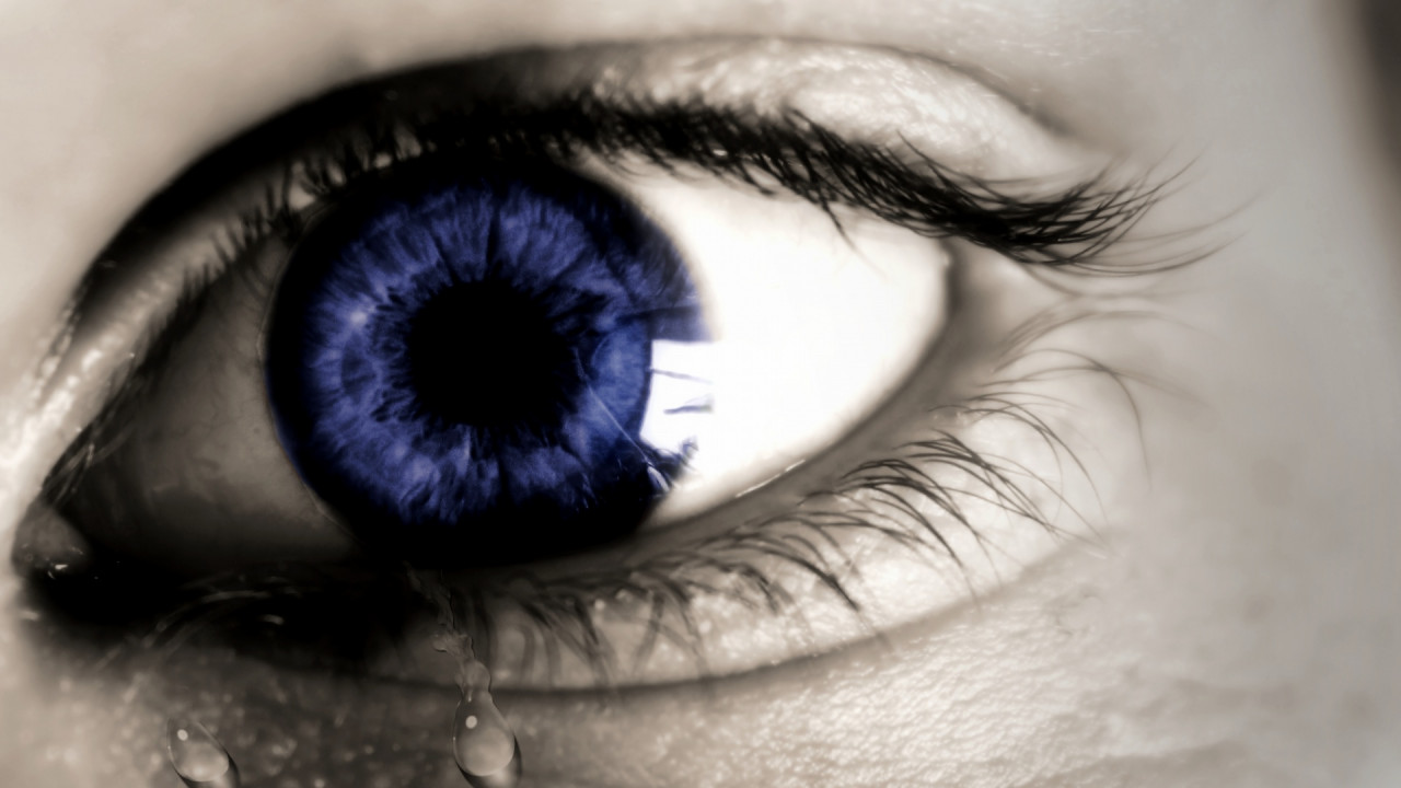A blue eye crying a tear.