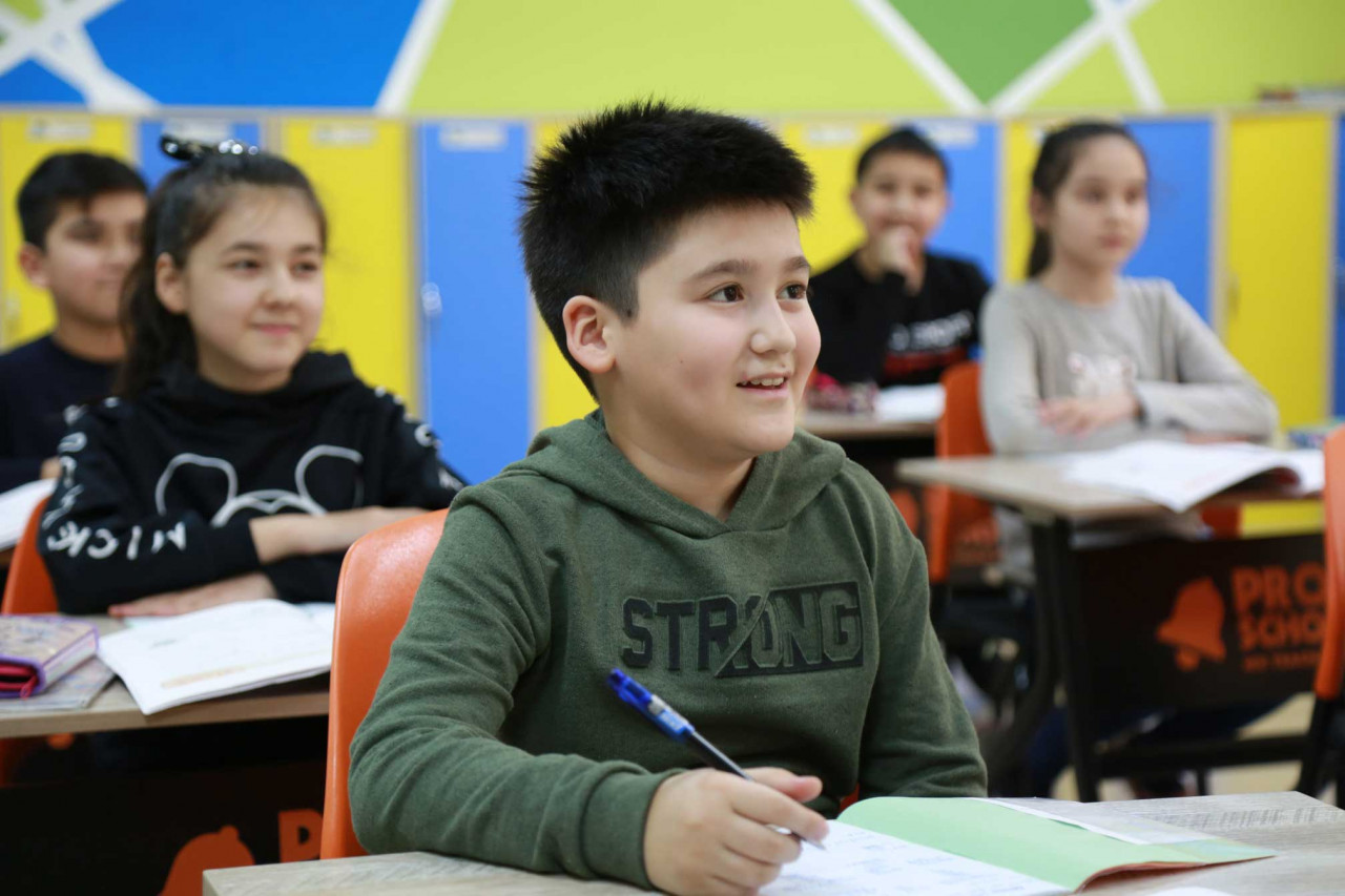 a student looking up and writing in a classroom