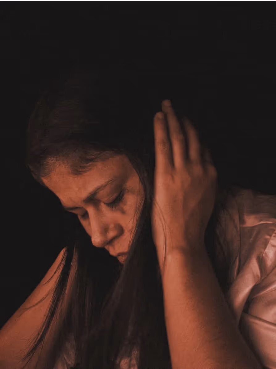 Woman with her eyes closed covering her ears with her hands