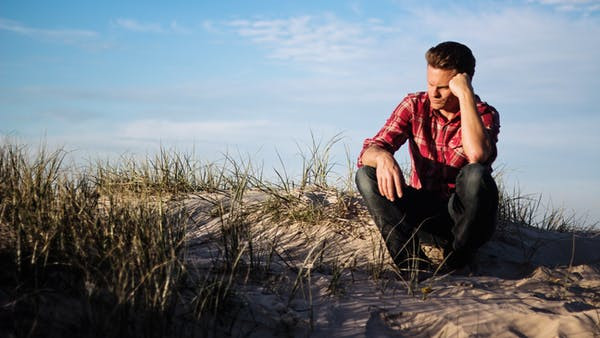 Man sitting on the ground thinking.