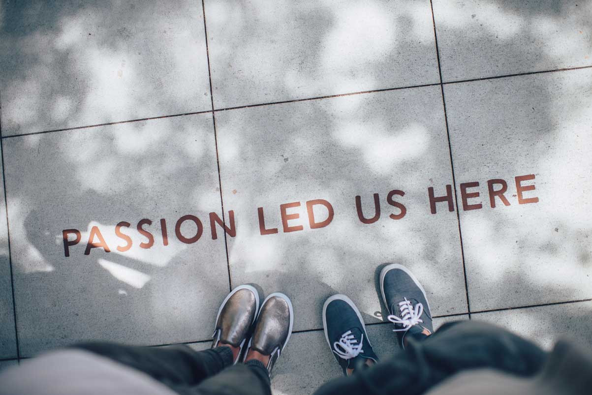 two people standing on a cement block that says passion led us here