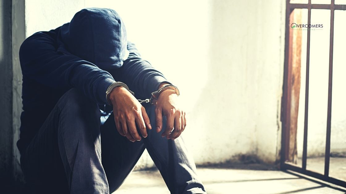 a person who is in handcuffs in a prison cell