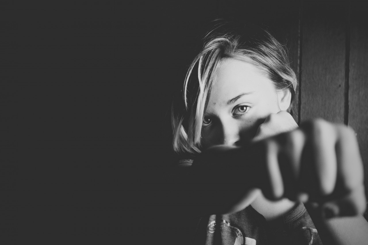 Black and white image of a woman holding up her fist toward the camera