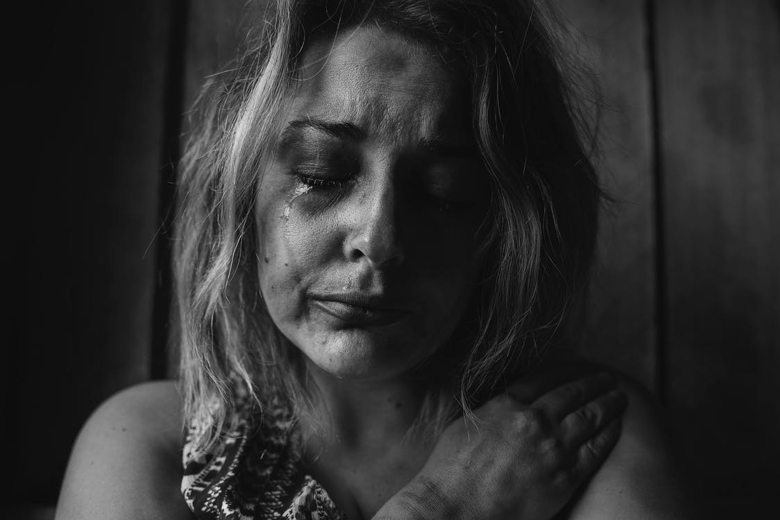 Woman with her eyes closed and a tear has fallen down her face.