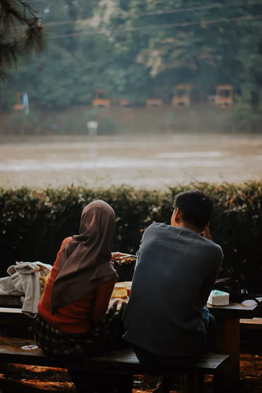 Two people sitting at a table outside together