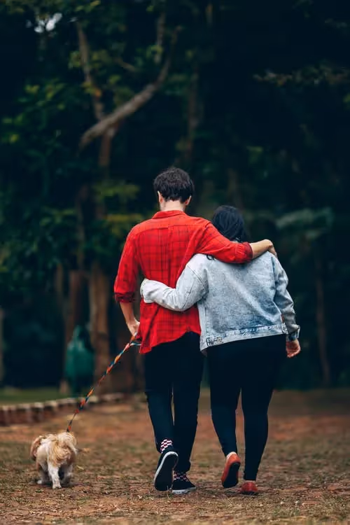 Man and woman with arms around each other on walk.