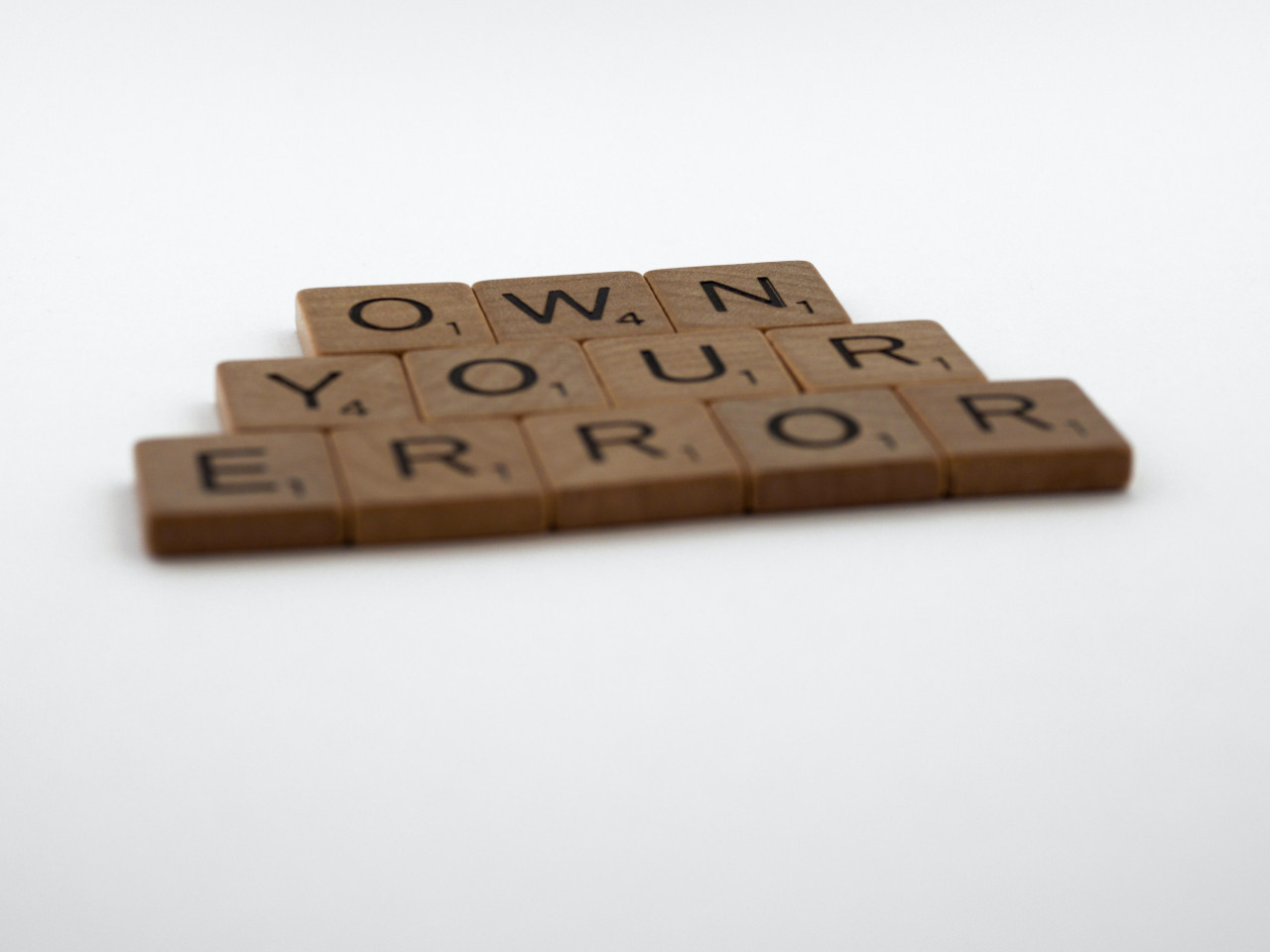 Own Your Error spelled out with scrabble tiles