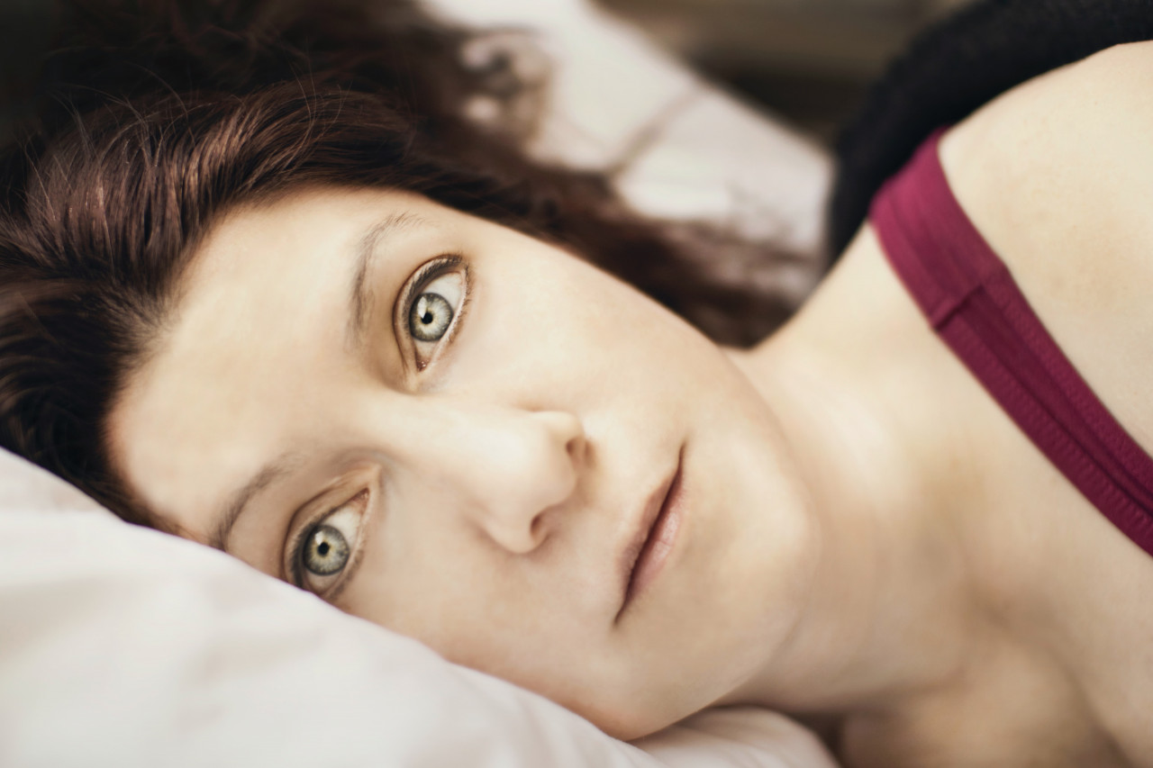 A woman laying on her side in bed
