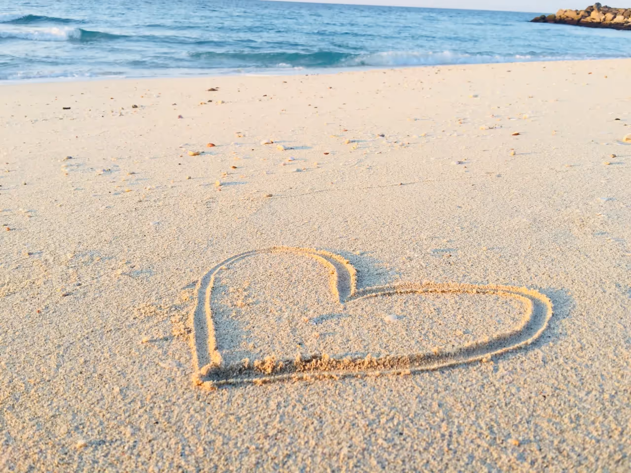 A heart drawn in the sand on the beach