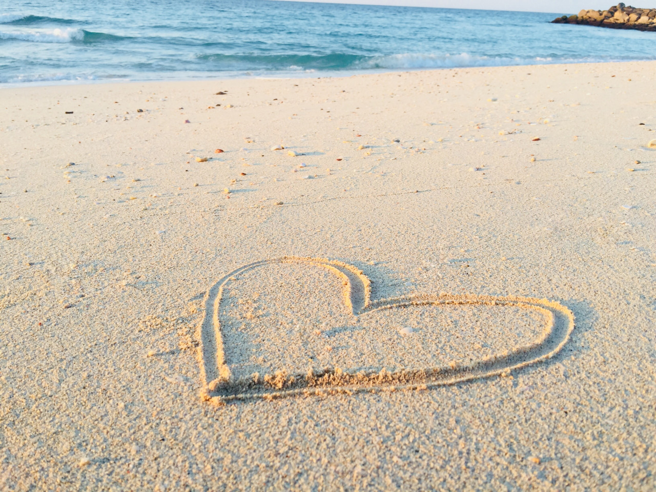 A heart drawn in the sand on the beach