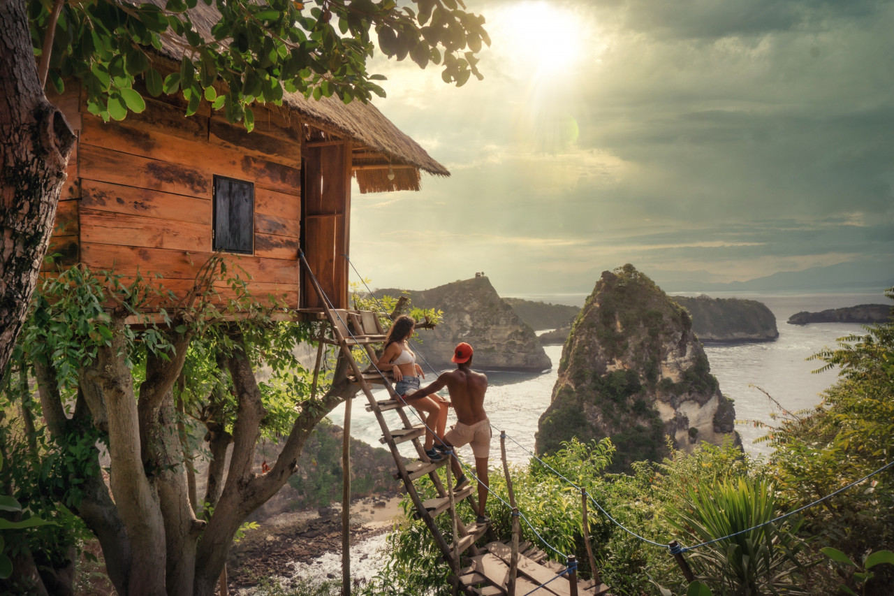 Couple on steps to a tree house overlooking the water.
