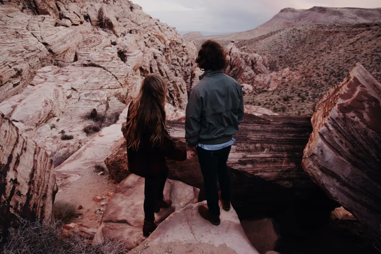 A couple standing on a rock overlooking a canyon
