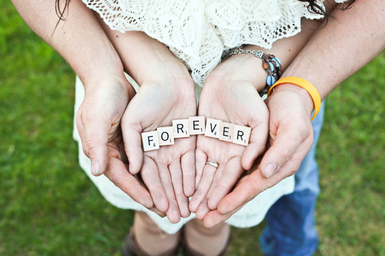 Forever spelled in out in scrabble letters in the palms of 2 peoples hands