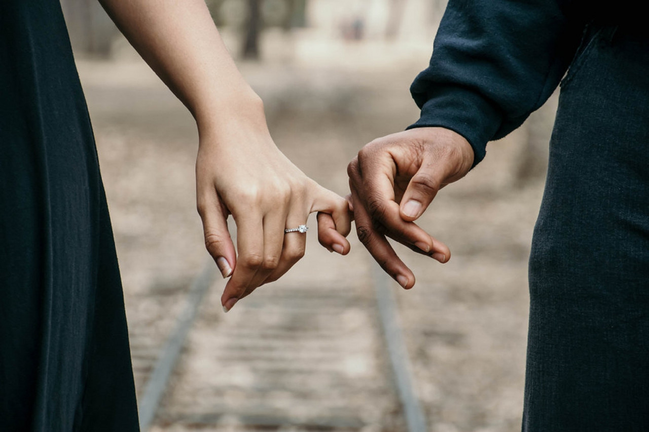 A couple with their pinkies interlocked