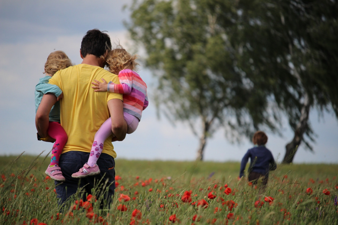 A father playing with his kids in a field