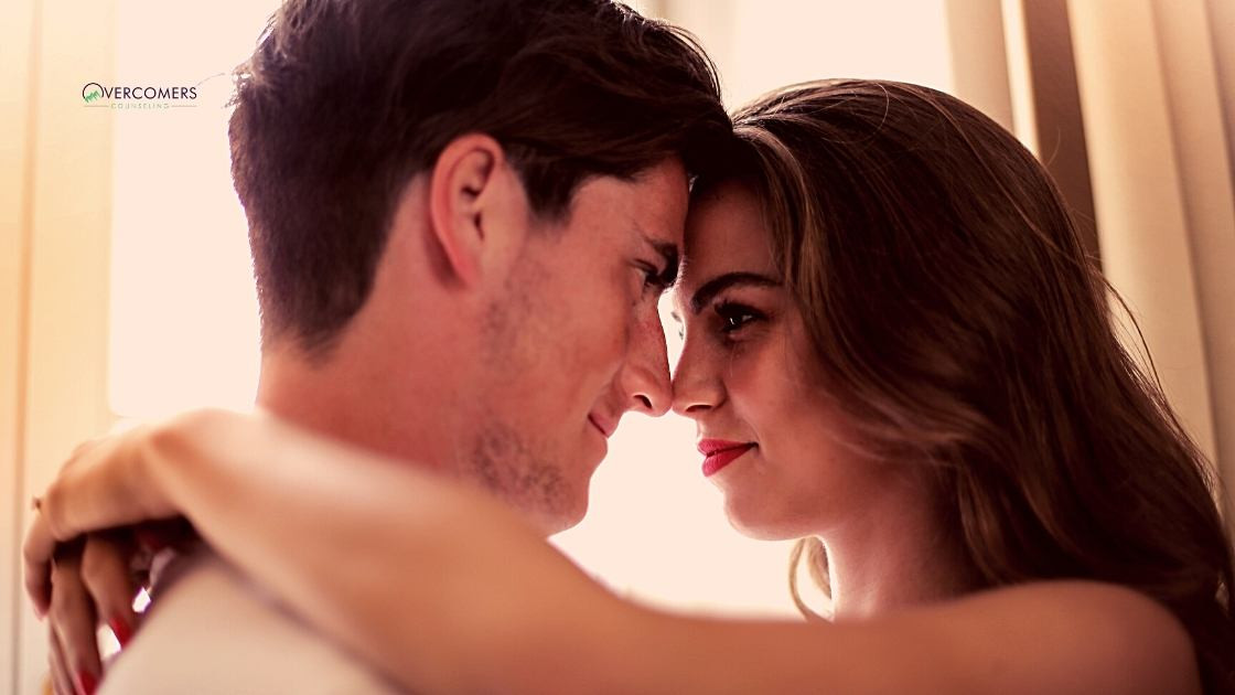 A woman and man looking at each other while their foreheads and noses are touching