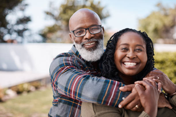 A man embracing a woman from behind.