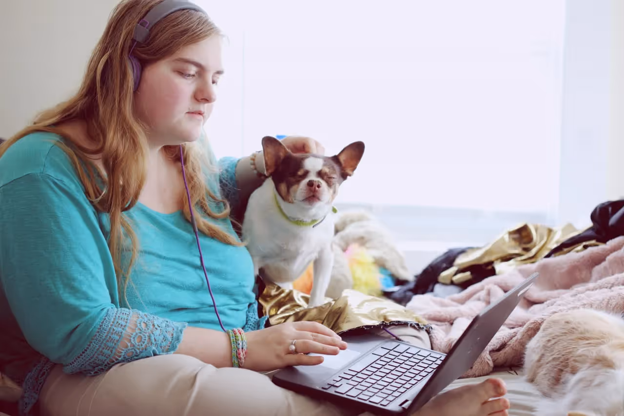 Woman sitting on a bed on her computer