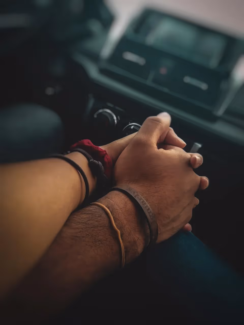 A couple holding hands in the car.