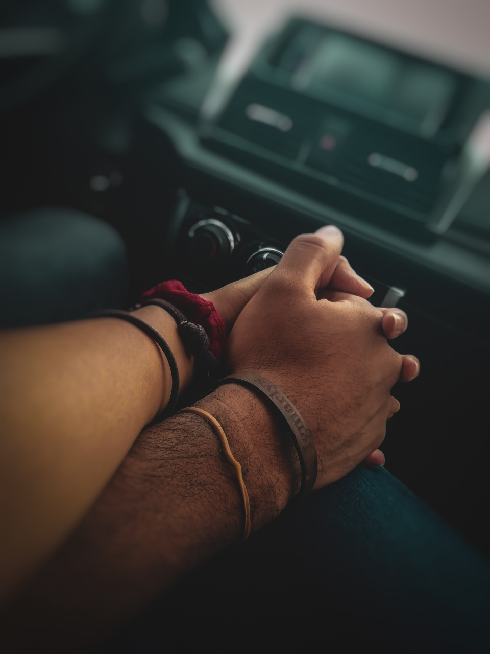 A couple holding hands in the car.