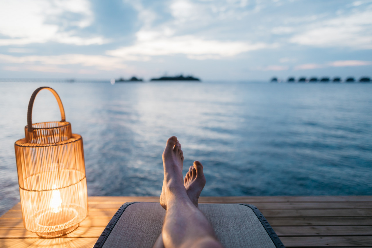 A man relaxing near a large body of water.