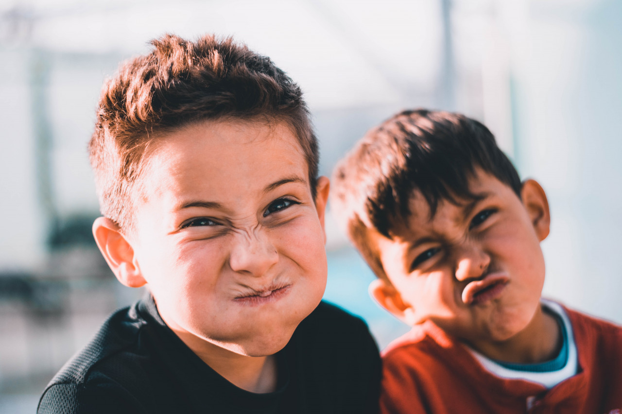 2 siblings making funny faces.