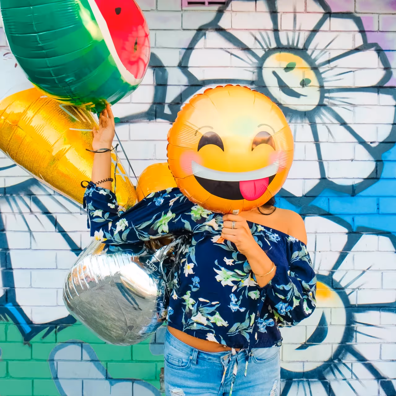 A lady having fun with inflatable emoji packs.