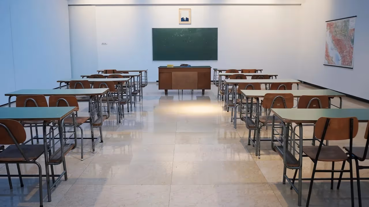 An empty classroom with desks and chairs.