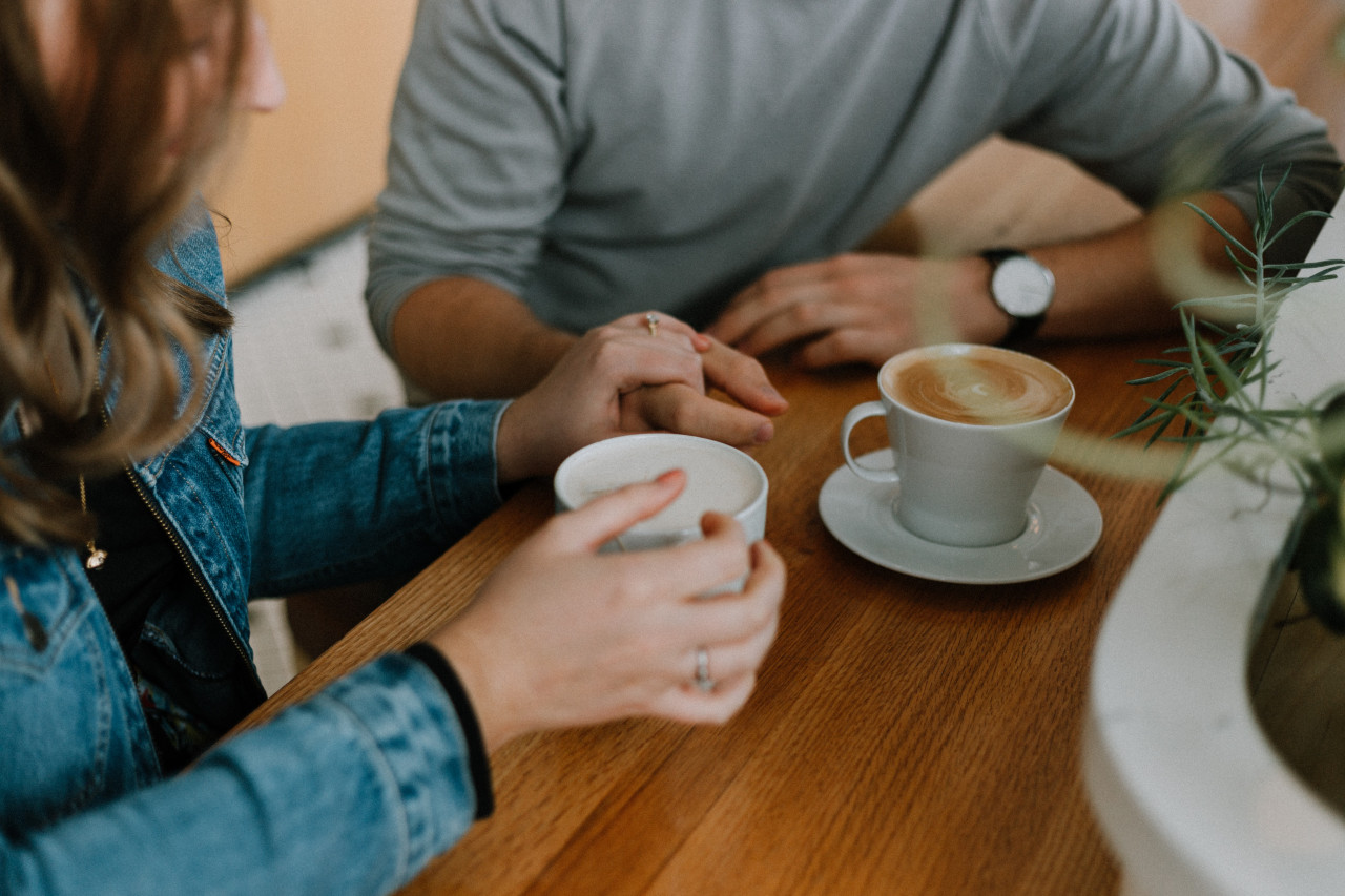 A man and woman sitting at a table drinking coffee