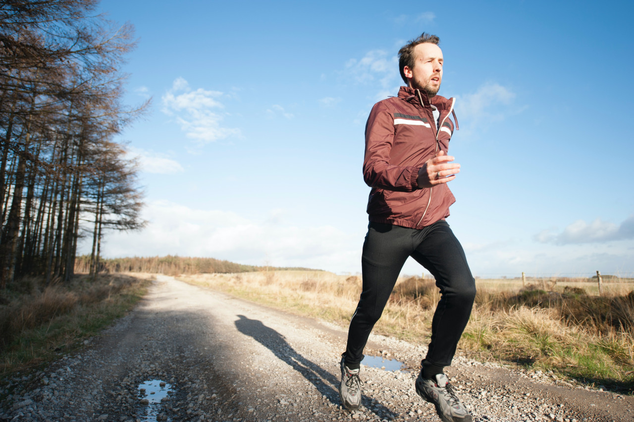 A man jogging on a rough road