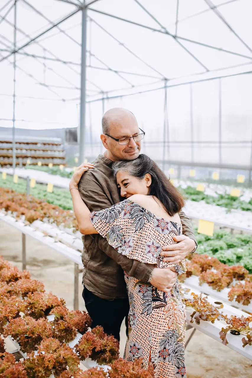 A man embracing a woman in a soothing garden.