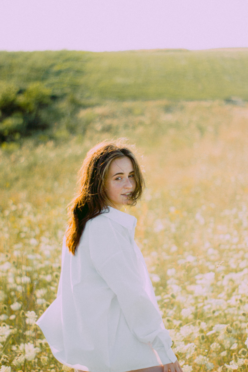 A lady hanging out in a calm field.