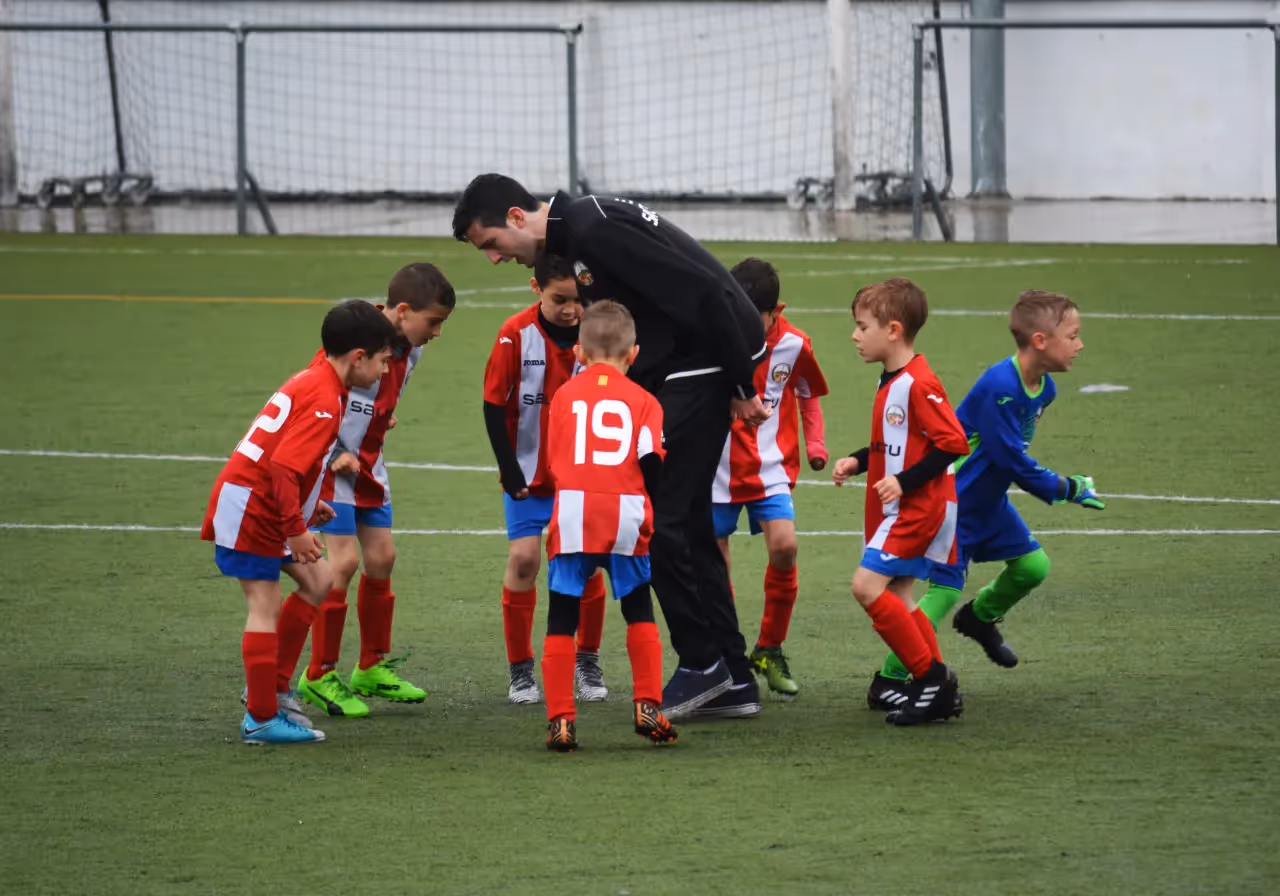 A group of kids on the field with their soccer coach