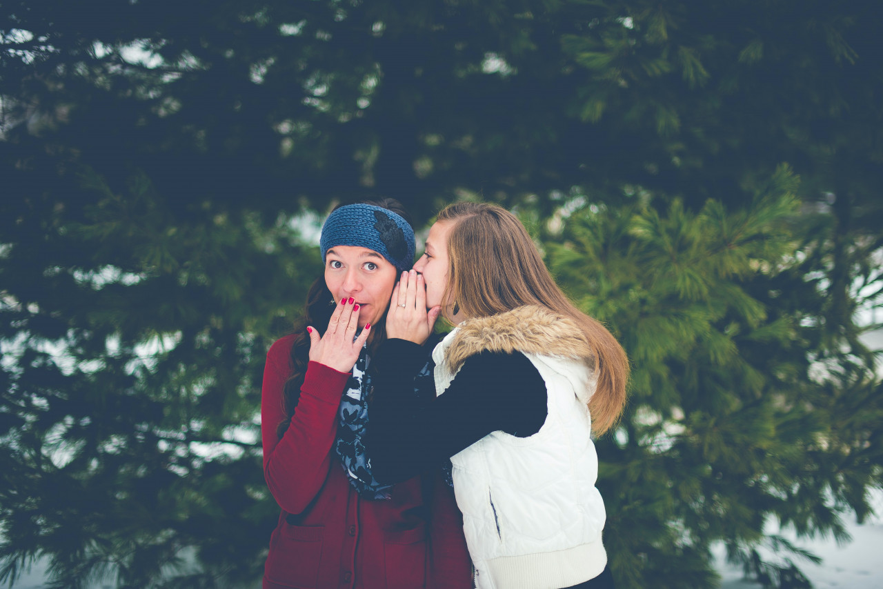 A girl whispering in her friends ear