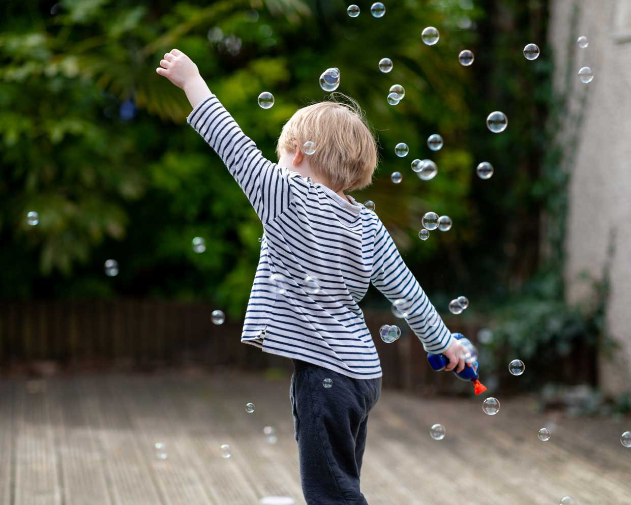 kid running through bubbles